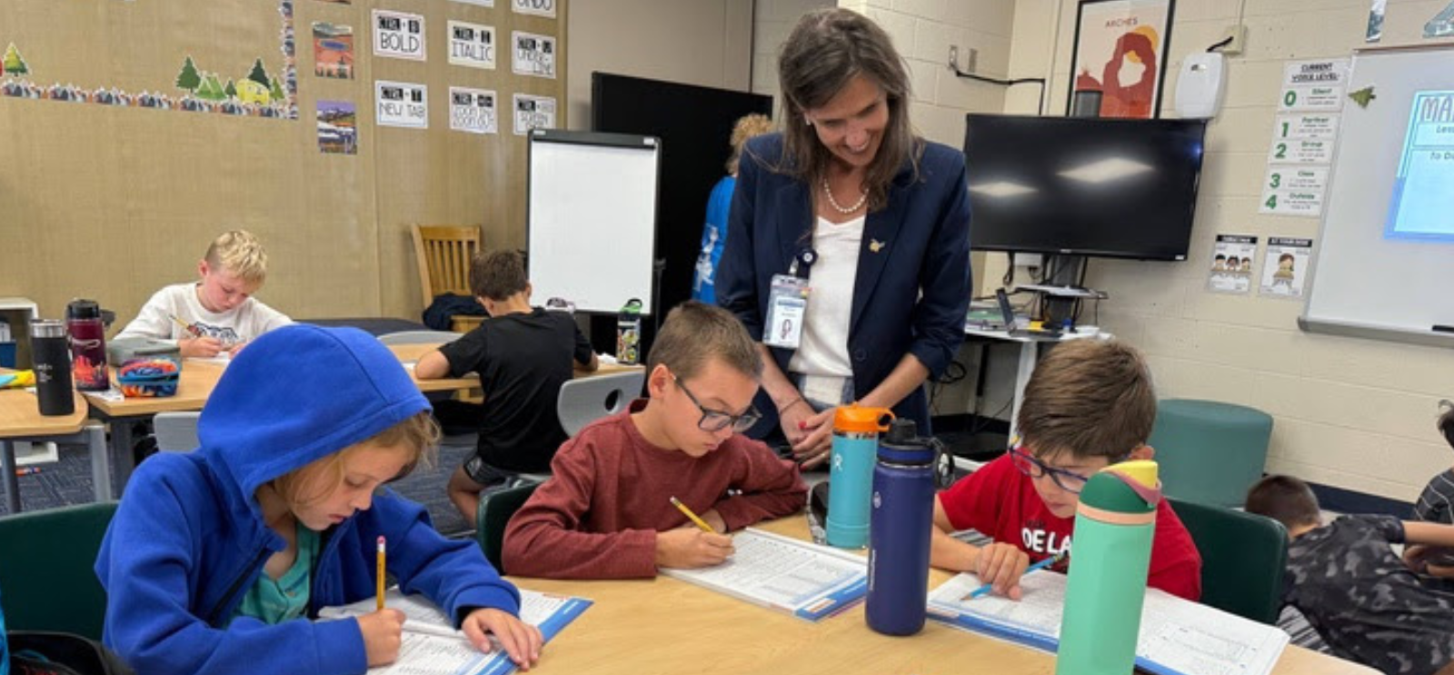Superintendent with students that are working in their math journals
